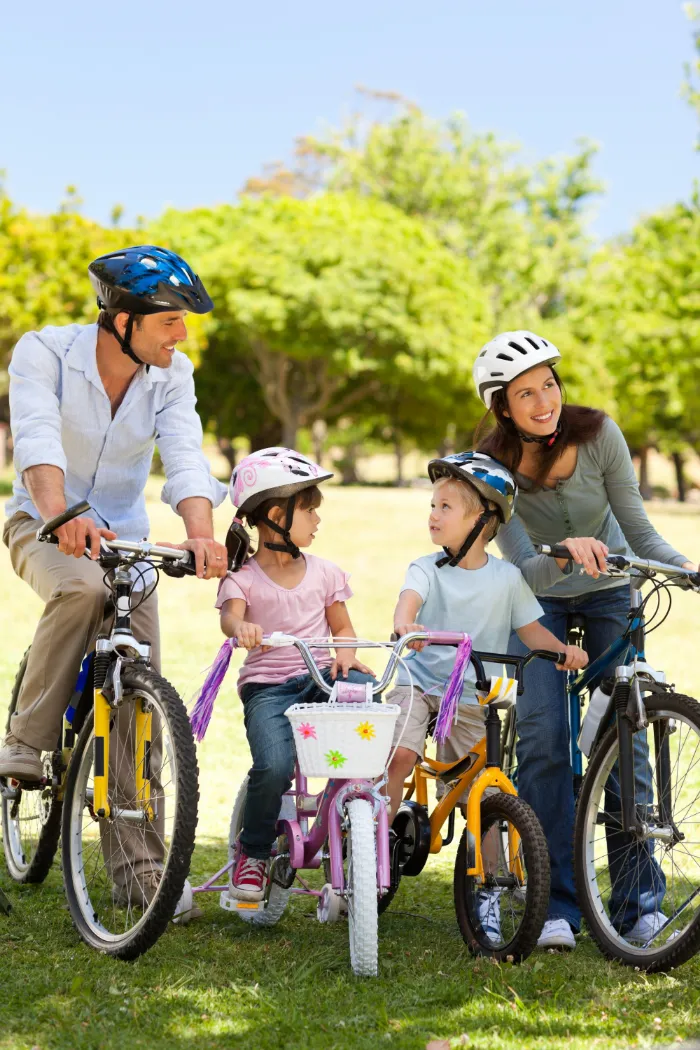 Famiglia in bici su un parco verde